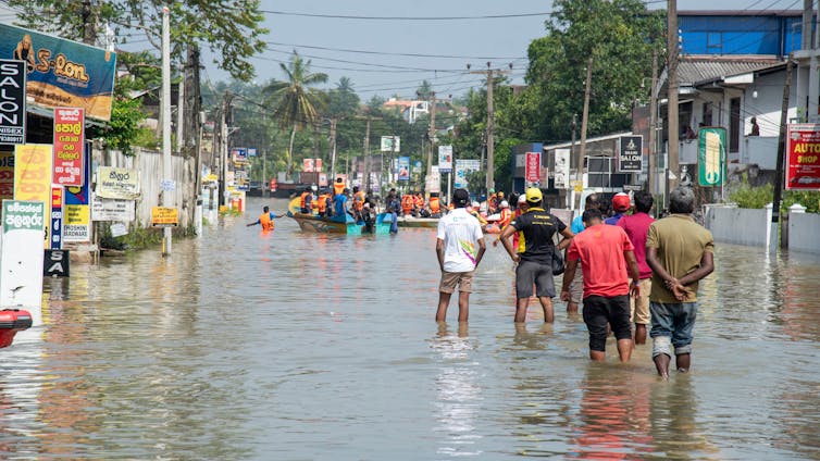 flooded streets, Sri Lankan people standing in damaged part of town after cyclone