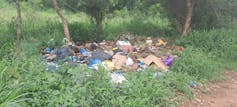 A piece of open land with trees where about 200 kilograms of garbage has been dumped