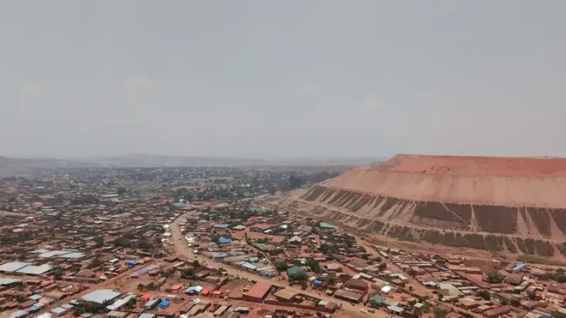 A residential area beside a large industrial mining site. 