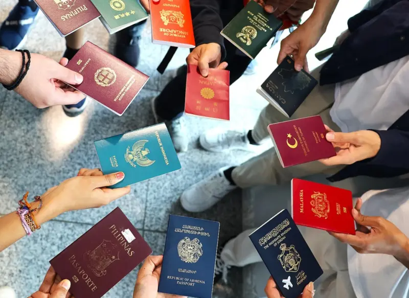 A group of people holding their passports at a Wikimania event in 2024.