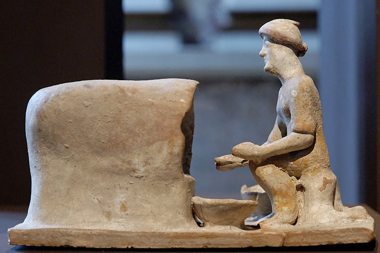 Terracotta figure of baker taking bread from oven