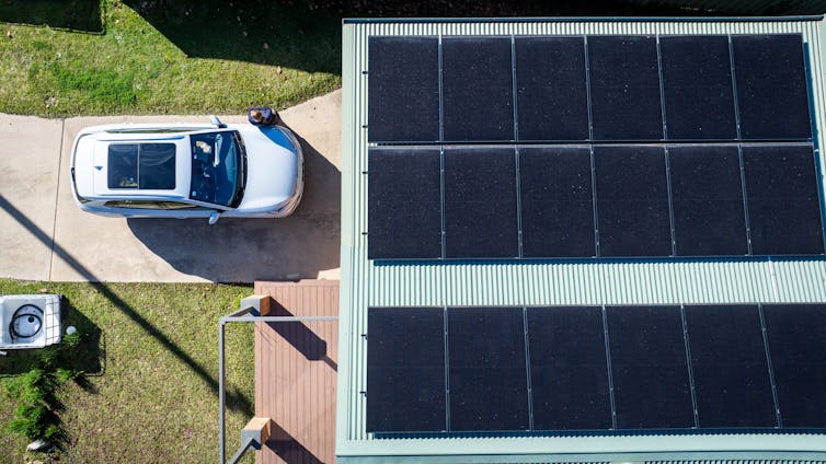 aerial view of a house with solar and an electric vehicle.