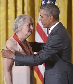 President Barack Obama with his hands on Annie Dillard's shoulders after placing a medal around her neck