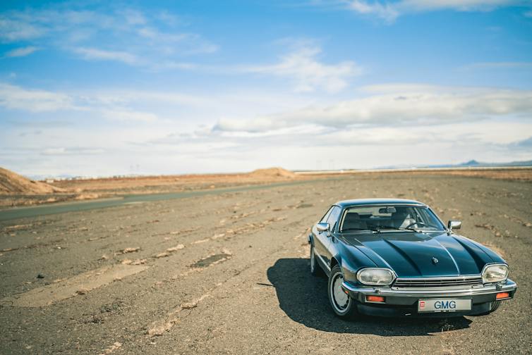 Classic Jaguar car in desert.