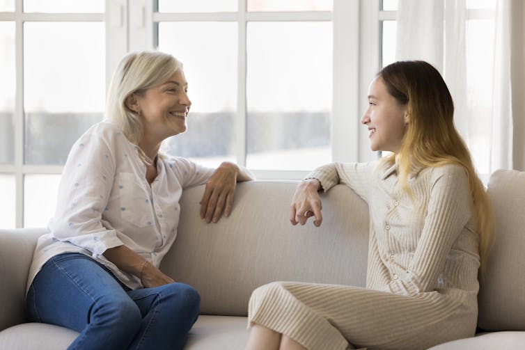 Woman and young woman talking on sofa