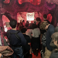 People standing inside a room decorated to look like a womb.