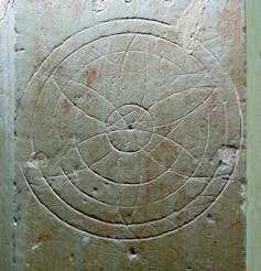 A hexafoil marking inscribed on stone.