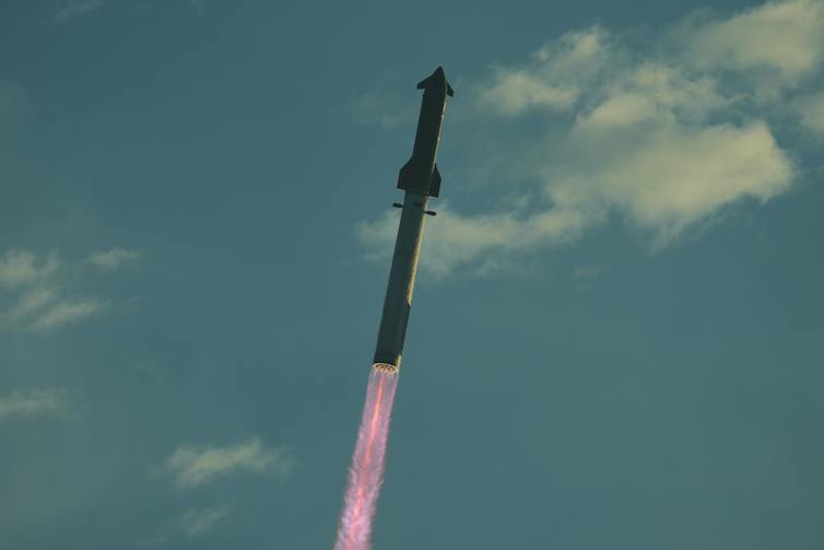 A rocket flying through the sky, propelled by a streak of flame