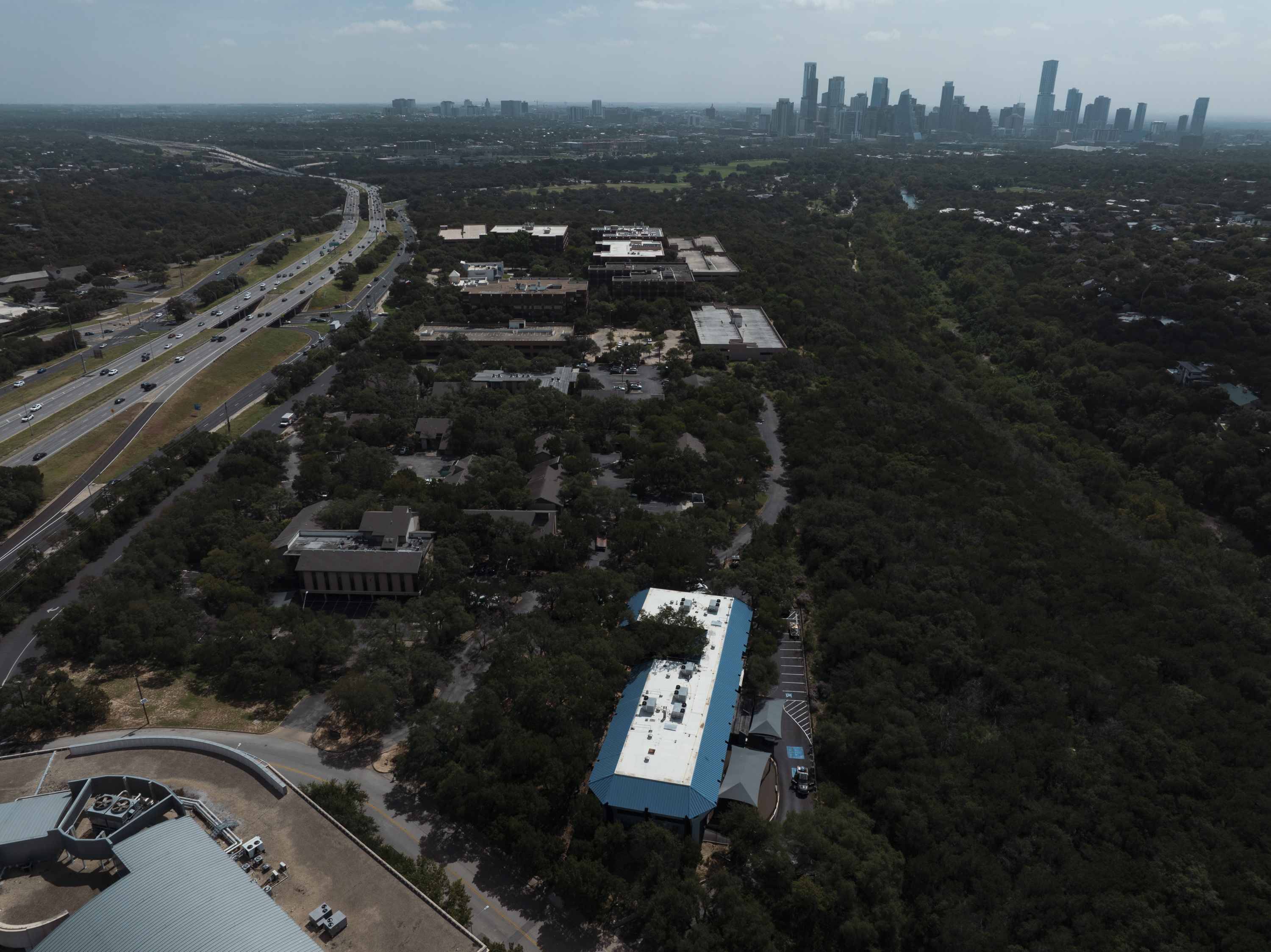 An aerial view of a blue and white building with Austin’s skyline in the background.