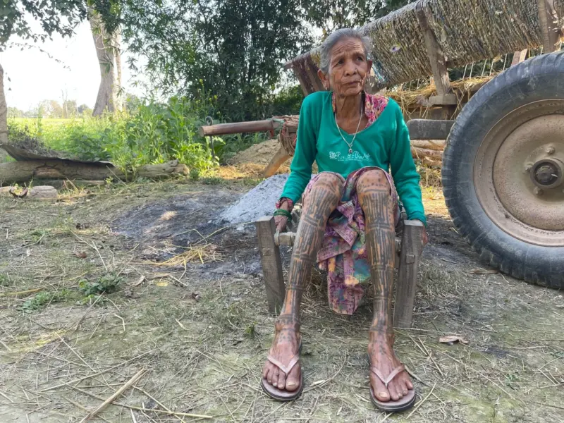 A Tharu woman with tattoos on her legs.