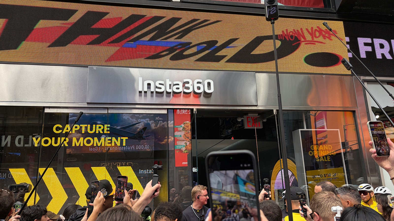 Crowd gathered outside the Insta360 store, with a digital sign displaying "THINK BOLD" and promotions for capturing moments