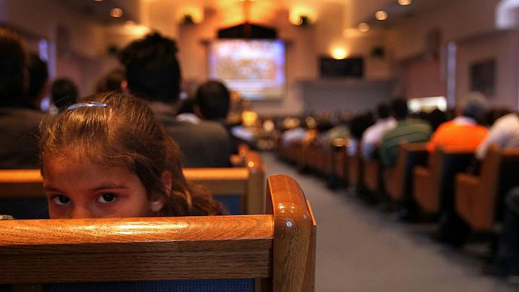 A sanctuary full of people, photographed from the back of the room.