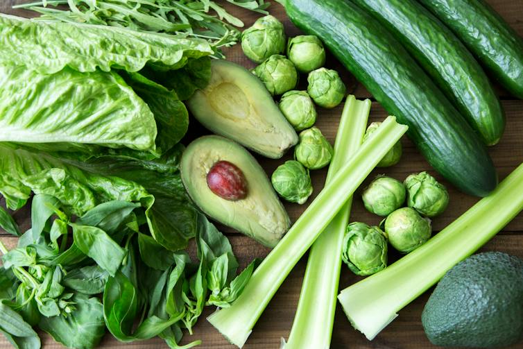 An assortment of foods that are rich in folate, including avocados, cucumbers, celery and lettuce.