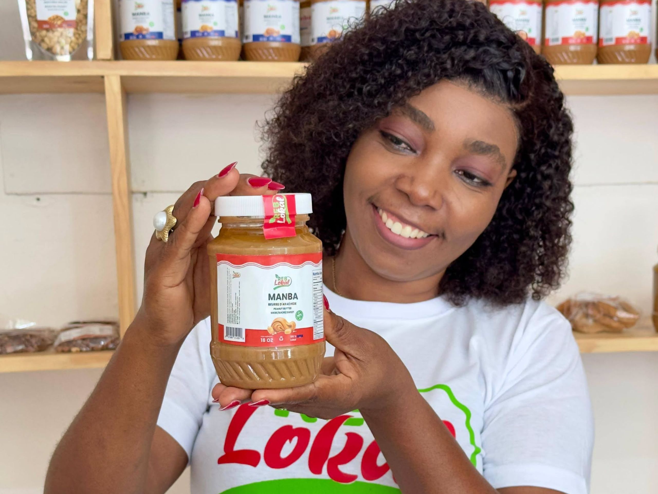 REB Lokal founder Rébetha Charles stands with a jar of peanut butter (manba lokal). Photo courtesy Charles, used with permission. 