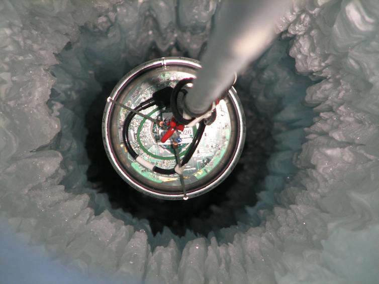 A metal rod stuck into a deep hole in the ice