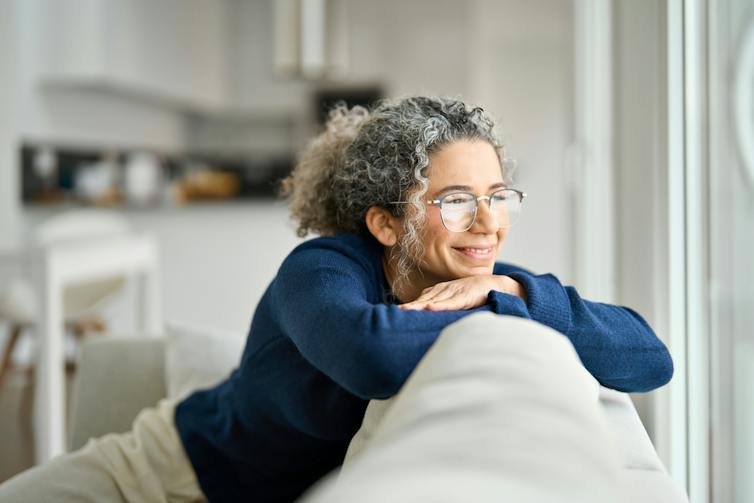 A woman sitting on a sofa, smiling.